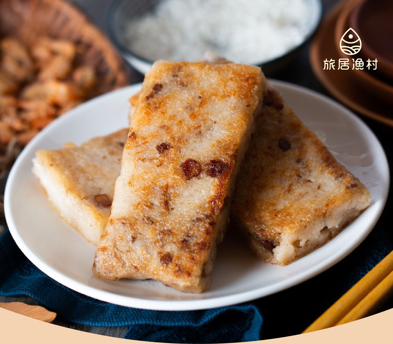 旅居漁村品牌的「寶寶米粿」，白色圓盤上疊放著三塊呈現金黃色澤、微焦酥脆的長方形米粿。米粿表面可見細碎的食材顆粒，質地紮實且富有手工感。整體色調溫暖、自然，強調食材的天然與適合嬰幼兒食用的健康形象。